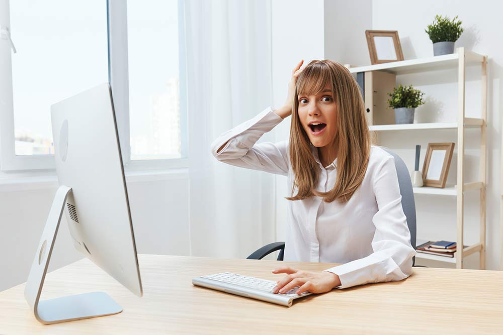 Eine Frau mit einem AHA Effekt vor ihrem PC